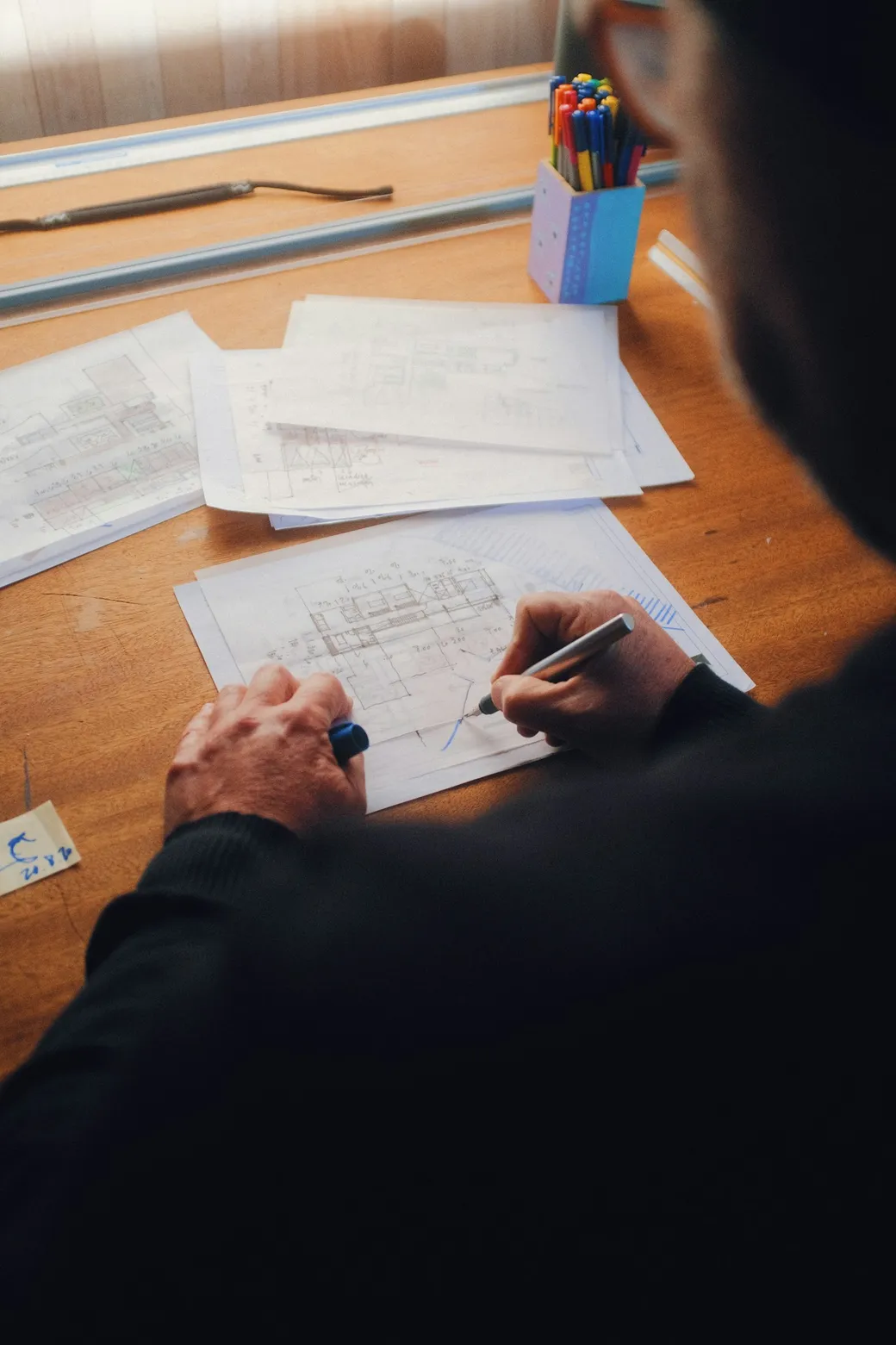 Persona revisando los planos de una propiedad sobre una mesa